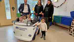 Paula (vorne, von links), Dejan, Emilia und Dilay erobern den VRmobil-Kinderbus. Filialdirektor Eckhard Paga (hinten, von links), Lara Torp und Bianca Ruttloff freuen sich mit ihnen.