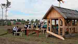 Die Besucher erleben, wie Zimmerer das Holz zu Balken verarbeiten und ein Fachwerkhaus errichten.